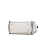 A white rectangular handbag shown from the bottom, featuring gold metal feet and black trim details.