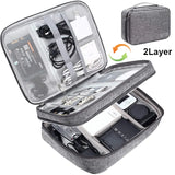 Gray travel electronics organizer case with two layers, equipped with compartments for cables, chargers, and devices.