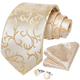 Beige tie with gold floral pattern, matching pocket square, and cufflinks on a white background