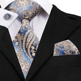 Blue and gold paisley tie, pocket square, and cufflinks on a black suit jacket.