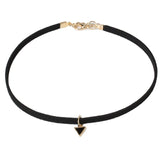 A simple black choker with a gold clasp and a small black triangle pendant hangs at the center. The design is minimalist and elegant.