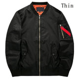 Black bomber jacket with an orange lining, zippered sleeve pocket with a red tag, and front snap button pockets. Text "Thin" in the upper right.