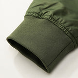 Close-up of a green jacket sleeve, featuring a ribbed cuff made of stretchy material. The fabric has a smooth texture, conveying a casual, cozy feel.