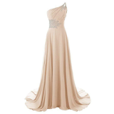 Elegant one-shoulder gown in soft beige with delicate silver embellishments at the neckline and waist, featuring a flowing, floor-length skirt.