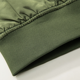 Close-up of an olive green jacket cuff, showing fine stitching and a ribbed texture. The fabric has a slightly glossy appearance, indicating quality material.